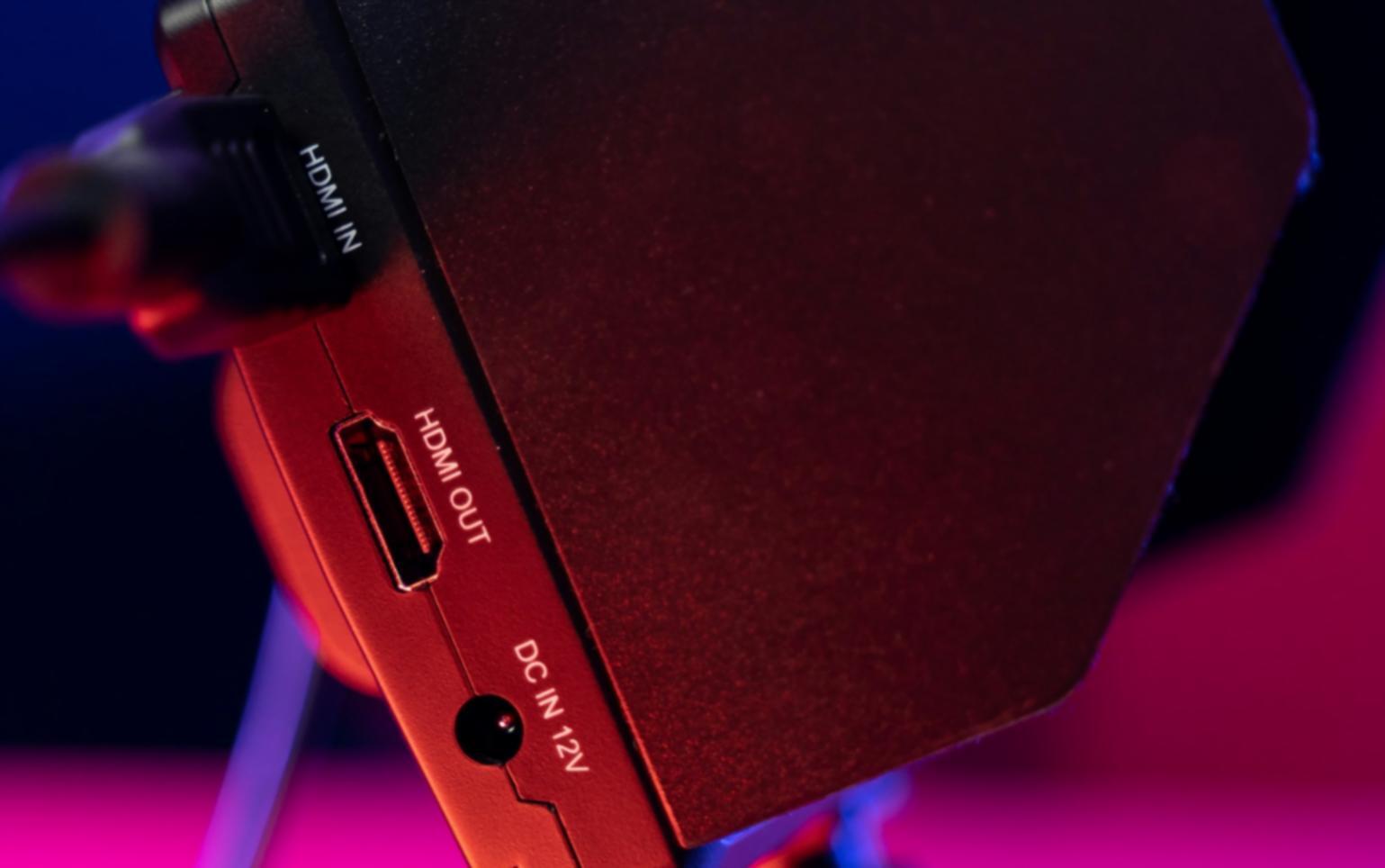 Instructor reviewing student work on multiple monitors showing timeline and preview screens